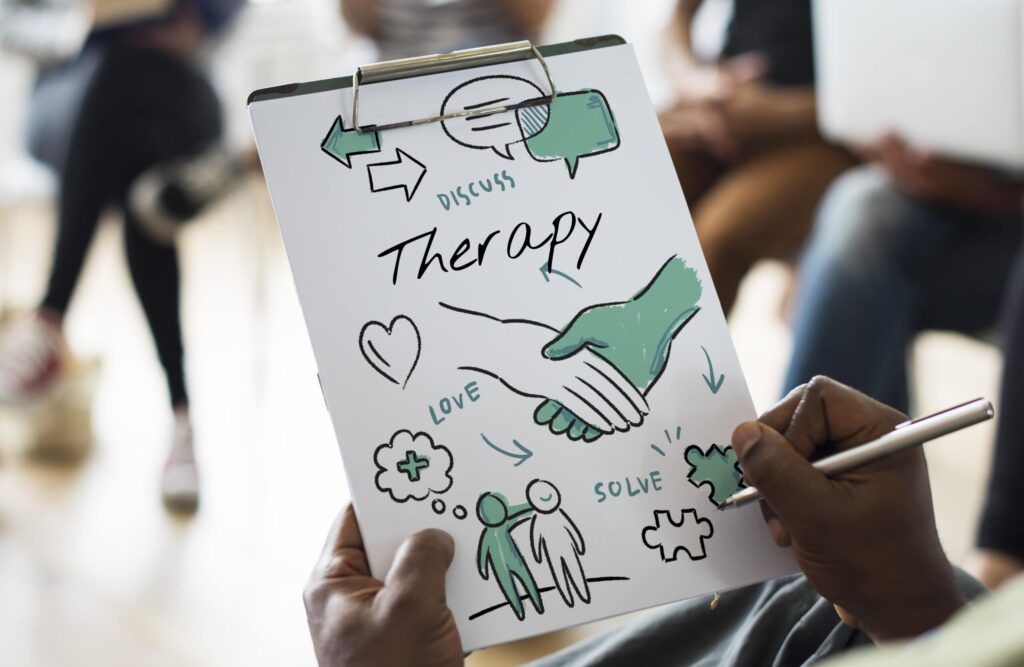 Therapist smiling and reviewing documents at desk, showcasing the time-saving benefits of therapy templates.